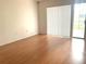 Bright bedroom featuring wood flooring and a sliding glass door with vertical blinds at 5530 Salem Square N Dr, Palm Harbor, FL 34685