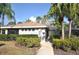 Exterior view of a single-story building with tropical landscaping and a sidewalk at 5530 Salem Square N Dr, Palm Harbor, FL 34685