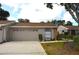 Charming single-story home with a beige exterior, two car garage and well-maintained landscaping at 5530 Salem Square N Dr, Palm Harbor, FL 34685