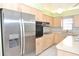 Kitchen with stainless steel refrigerator and plenty of cabinet and counter space at 5530 Salem Square N Dr, Palm Harbor, FL 34685