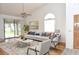 Bright living room with vaulted ceilings, large windows, and a ceiling fan at 5530 Salem Square N Dr, Palm Harbor, FL 34685