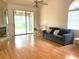 Bright living room boasts hardwood floors, a cozy sofa, and a sliding glass door offering outdoor views at 5530 Salem Square N Dr, Palm Harbor, FL 34685