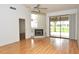 Spacious living room with a fireplace, ceiling fan, and sliding doors at 5530 Salem Square N Dr, Palm Harbor, FL 34685
