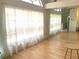 Bright living room with sheer curtains, mirrored wall, and hardwood flooring at 5530 Salem Square N Dr, Palm Harbor, FL 34685