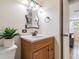 Bathroom featuring a wood vanity with a marble countertop, decorative mirror, and modern fixtures at 6706 S Trask St, Tampa, FL 33616