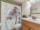 Bathroom featuring a wood vanity with a marble countertop, decorative mirror, and a shower with a tree-themed curtain at 6706 S Trask St, Tampa, FL 33616
