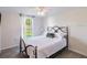 Well-lit bedroom with wood floors, a comfortable bed, and a window overlooking the landscaped yard at 6706 S Trask St, Tampa, FL 33616