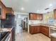 Functional kitchen featuring wood cabinets, updated appliances, and a convenient layout at 6706 S Trask St, Tampa, FL 33616