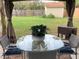 Relaxing outdoor patio with comfortable seating and a glass table overlooking the green backyard at 6706 S Trask St, Tampa, FL 33616