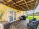 Covered outdoor patio with wicker chairs, a grill, and a dining area, perfect for outdoor entertaining at 6706 S Trask St, Tampa, FL 33616