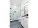 Modern bathroom featuring a glass enclosed shower with decorative black and white tile and a white vanity at 723 W 113Th Ave, Tampa, FL 33612