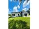 Landscaped lawn of a modern designed home with a black two-car garage and light blue front door at 723 W 113Th Ave, Tampa, FL 33612