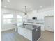 Bright kitchen features a center island, white cabinets, light gray countertops, and stainless steel microwave at 723 W 113Th Ave, Tampa, FL 33612