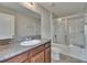 Bathroom featuring a shower with glass doors, granite countertop, and wood cabinets at 7325 Parkshore Dr, Apollo Beach, FL 33572
