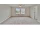 Bright bedroom with carpeted floors, ceiling fan, and two sunlit windows at 7325 Parkshore Dr, Apollo Beach, FL 33572