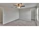 Cozy bedroom featuring soft carpet, a ceiling fan, and hall access at 7325 Parkshore Dr, Apollo Beach, FL 33572