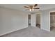 Neutral bedroom with gray carpet, a ceiling fan, and an ensuite bath and walk in closet at 7325 Parkshore Dr, Apollo Beach, FL 33572