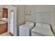 Laundry room featuring white washer, dryer, overhead storage, and natural light at 7325 Parkshore Dr, Apollo Beach, FL 33572