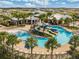Community pool featuring water slides, palm trees, lounge chairs, and a modern recreational building at 7325 Parkshore Dr, Apollo Beach, FL 33572
