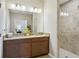 Bathroom featuring double sinks, granite countertops, and a tiled shower at 810 Hillshire Pl, Spring Hill, FL 34609