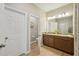 Well-lit bathroom with double sinks, granite countertops, and a separate toilet room at 810 Hillshire Pl, Spring Hill, FL 34609