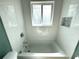 Bright bathroom showcasing a soaking tub and window, tiled walls, and a recessed shelf at 814 19Th Sw St, Largo, FL 33770