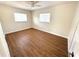 Bright bedroom featuring wood-look flooring, fresh paint, two windows, and a ceiling fan at 814 19Th Sw St, Largo, FL 33770