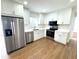Renovated kitchen featuring stainless steel appliances, white cabinets, and sleek countertops with wood-look flooring at 814 19Th Sw St, Largo, FL 33770