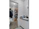 Bathroom featuring a sink and vanity, closet with shelving, and patterned wallpaper at 8248 Irene St, Zephyrhills, FL 33540