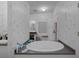 Bathroom featuring a soaking tub, separate vanity and patterned wallpaper at 8248 Irene St, Zephyrhills, FL 33540