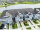 Aerial view of a row of townhomes in a community with a lake nearby at 9140 Hillcroft Dr, Riverview, FL 33578