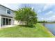 View of the back yard and exterior elevation of the property backing to a community pond at 9140 Hillcroft Dr, Riverview, FL 33578