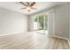 Bright bedroom with a ceiling fan, wood flooring, and sliding glass doors to the backyard, perfect for relaxation at 9140 Hillcroft Dr, Riverview, FL 33578