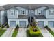 Attractive townhome featuring gray siding, a two-car garage, and well-maintained landscaping at 9140 Hillcroft Dr, Riverview, FL 33578