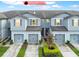 Exterior view of gray townhouses with landscaped yards and attached garages at 9140 Hillcroft Dr, Riverview, FL 33578