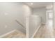 Upstairs hallway has light wood floors and neutral paint at 9140 Hillcroft Dr, Riverview, FL 33578