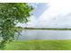 Scenic view of a tranquil lake surrounded by lush green grass and neighborhood homes in the distance at 9140 Hillcroft Dr, Riverview, FL 33578