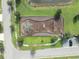 Overhead view of a community playground surrounded by lush green grass, trees, and a lake at 9140 Hillcroft Dr, Riverview, FL 33578