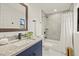 Bathroom featuring a granite countertop, modern fixtures, and a shower with gray tiling at 9511 N Hyaleah Rd, Tampa, FL 33617