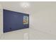 Bright bedroom features a modern accent wall, ample natural light and sleek tile flooring at 9511 N Hyaleah Rd, Tampa, FL 33617