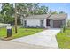 Charming single-story home featuring a well-manicured lawn, driveway, and stone accents at 9511 N Hyaleah Rd, Tampa, FL 33617