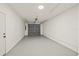 Spacious garage with a roll-up door and ample room for storage or vehicles, featuring clean, painted walls at 9511 N Hyaleah Rd, Tampa, FL 33617