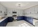 Modern kitchen with two-tone cabinets, stainless steel appliances, and marble flooring at 9511 N Hyaleah Rd, Tampa, FL 33617