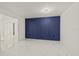 An empty, bright room showcasing white marble floors and blue paneled accent wall at 9511 N Hyaleah Rd, Tampa, FL 33617