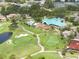 Aerial view of the community featuring a golf course, clubhouse, pool, and lush landscaping, a picturesque setting at 9800 Sago Point Dr, Seminole, FL 33777