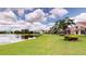 Expansive backyard features a lush lawn and a tranquil lake view, creating a serene outdoor living space at 9800 Sago Point Dr, Seminole, FL 33777
