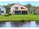 Scenic backyard view featuring a screened-in porch and a tranquil pond, creating a serene outdoor space at 9800 Sago Point Dr, Seminole, FL 33777