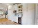 Modern bar with wine fridge, microwave, and wine rack adjacent to kitchen with abundant storage at 9800 Sago Point Dr, Seminole, FL 33777