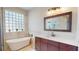Elegant bathroom with a soaking tub, vanity with marble countertops, and glass block window at 9800 Sago Point Dr, Seminole, FL 33777