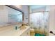 Bathroom featuring marine-themed shower curtain, anchor, and a large mirror reflecting a cozy, well-lit interior at 9800 Sago Point Dr, Seminole, FL 33777